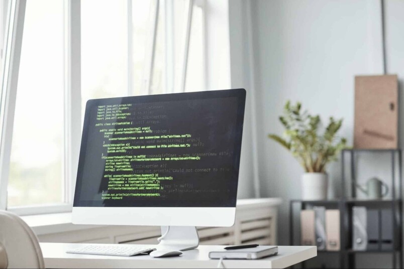 Code on a computer monitor showcasing programming script at a desk in a modern learning environment for IT or computer networking courses.
