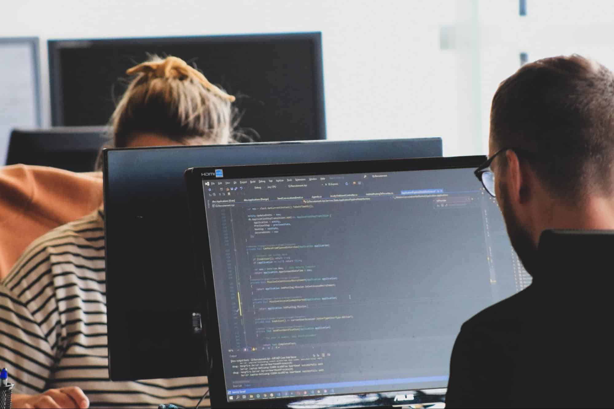 Coding students programming at computers in a classroom, emphasizing IT training and computer career education from MyComputerCareer.