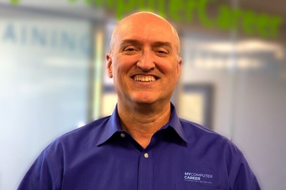 Certified IT professional smiling at MyComputerCareer school, focused on tech training and career development, promoting IT education and certification programs for a better future.