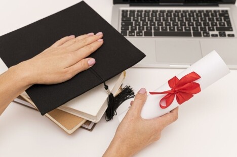 Graduation cap and diploma with a laptop on a white desk, highlighting online IT training and career development at MyComputerCareer.